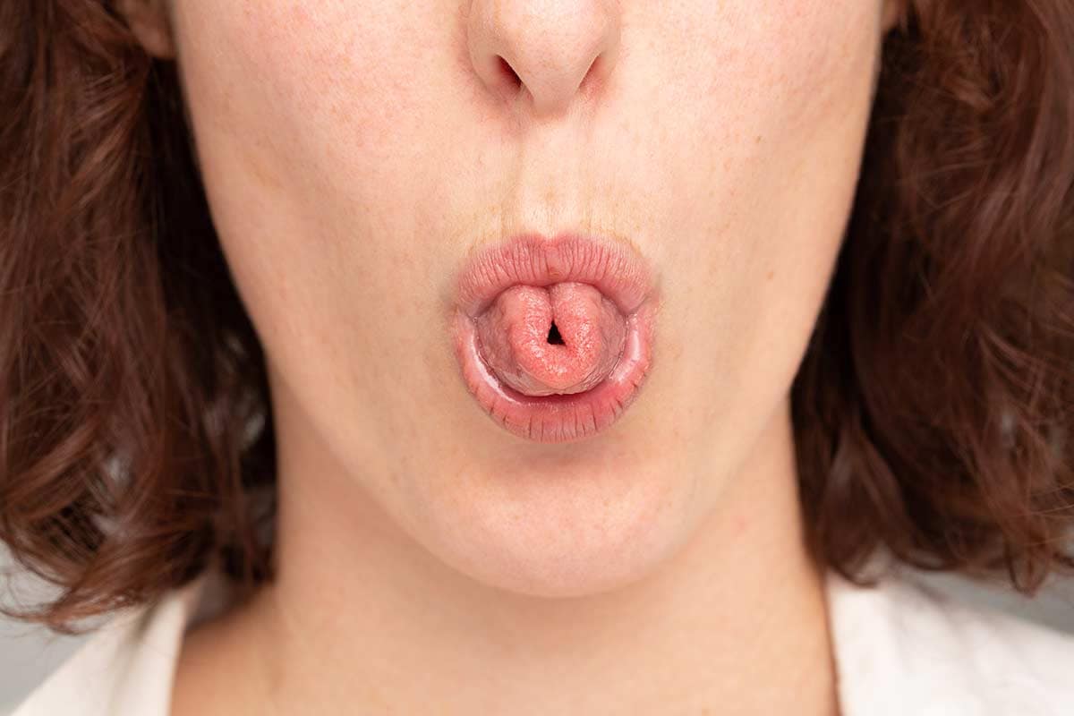 Close up of a woman rolling tongue in Orofacial Myofunctional Therapy.