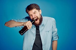 Man opening bottle with teeth