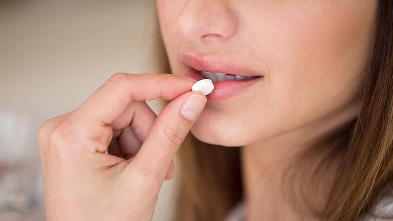 A woman taking medication.