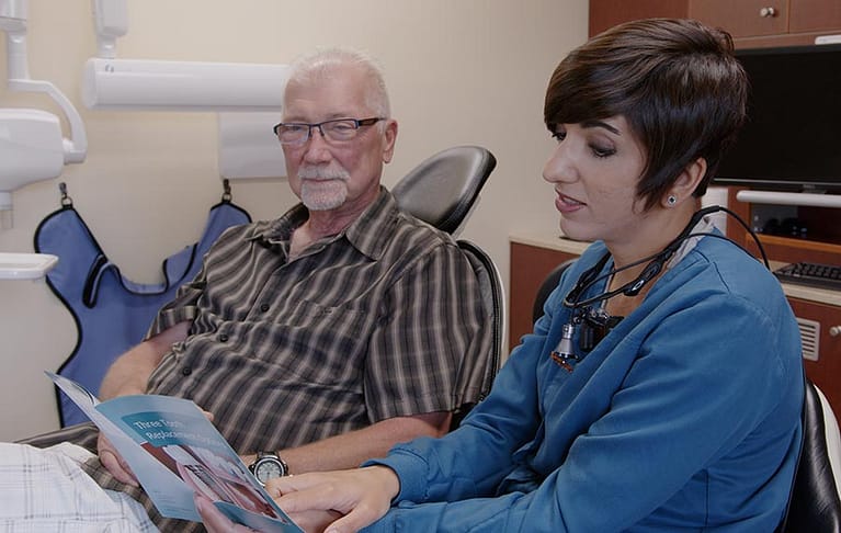 Dentist and patient talking about gum disease.